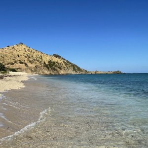 Hill in backdrop along shoreline with clear water as photography location