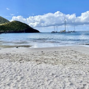 Powder white sandy beach on Caribbean sea with catamarans