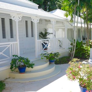 Colonial white painted wooden house with porch on pool deck