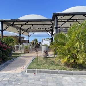 Steel construction with open sides and greenery white roof on the beach