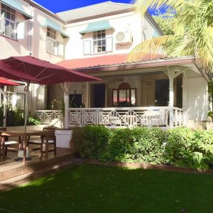 Traditional Caribbean brickhouse in light colour with patio and shatters