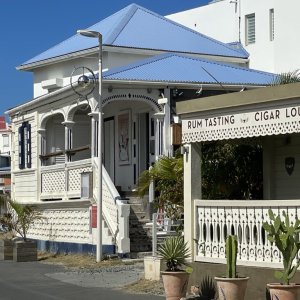 White French Caribbean style house with playfully carved wood decor and rails