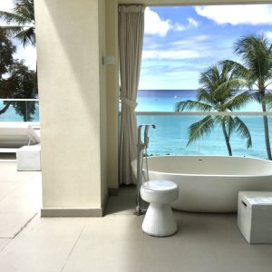 Bathtub in open air environment with view to palm trees and sea