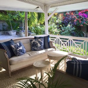 Exclusive Caribbean style sitting open air living area surrounded by blooming bushes