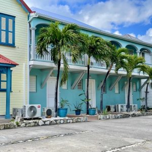 Colorful French colonial style houses with porches lined up along a village street in Saint Martin