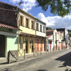 Traditional old stone houses painted in multi colors lined along a quiet village street in Martinique